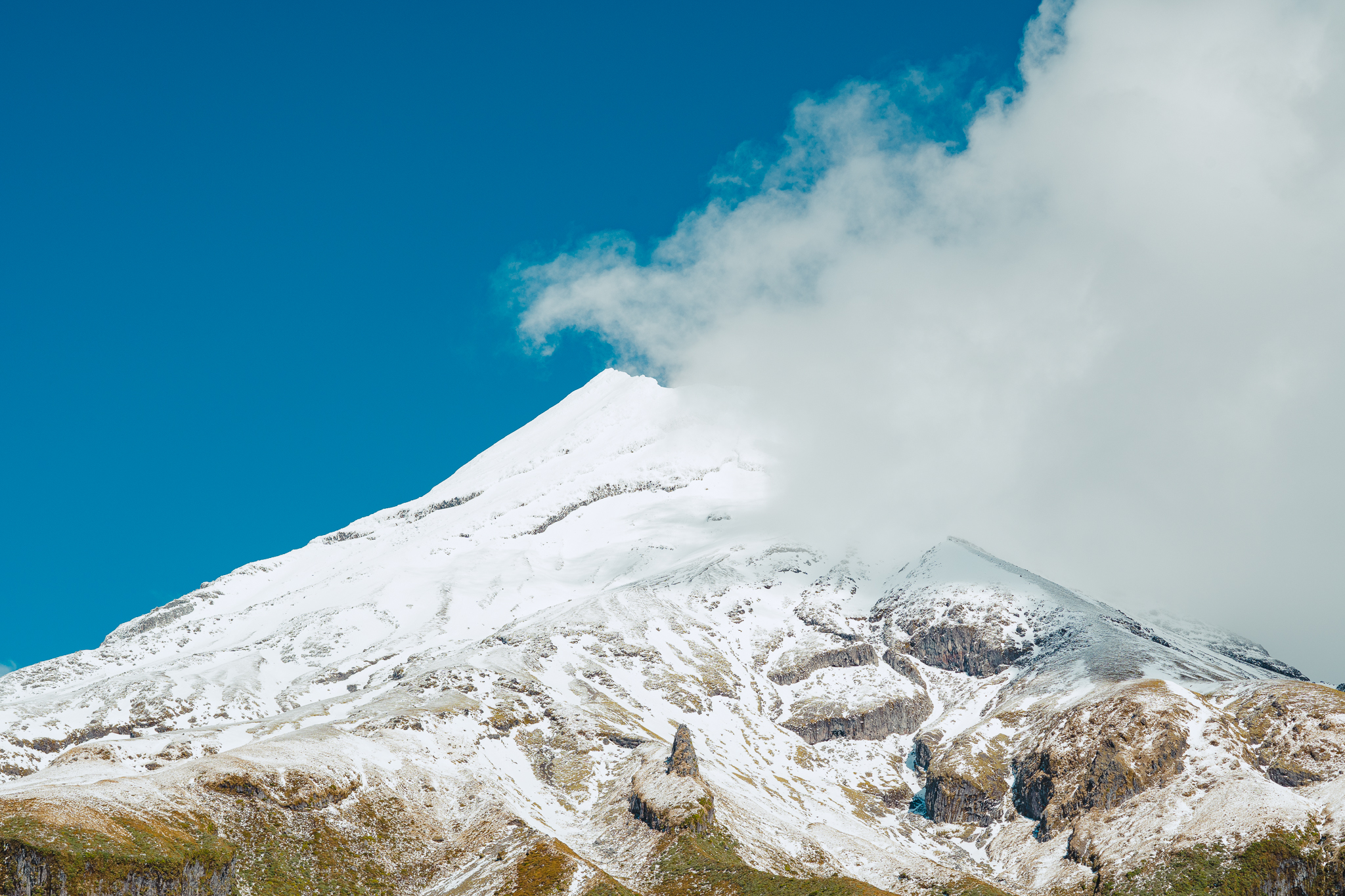 Close up of Mount Taranaki semi-covered by a cloud