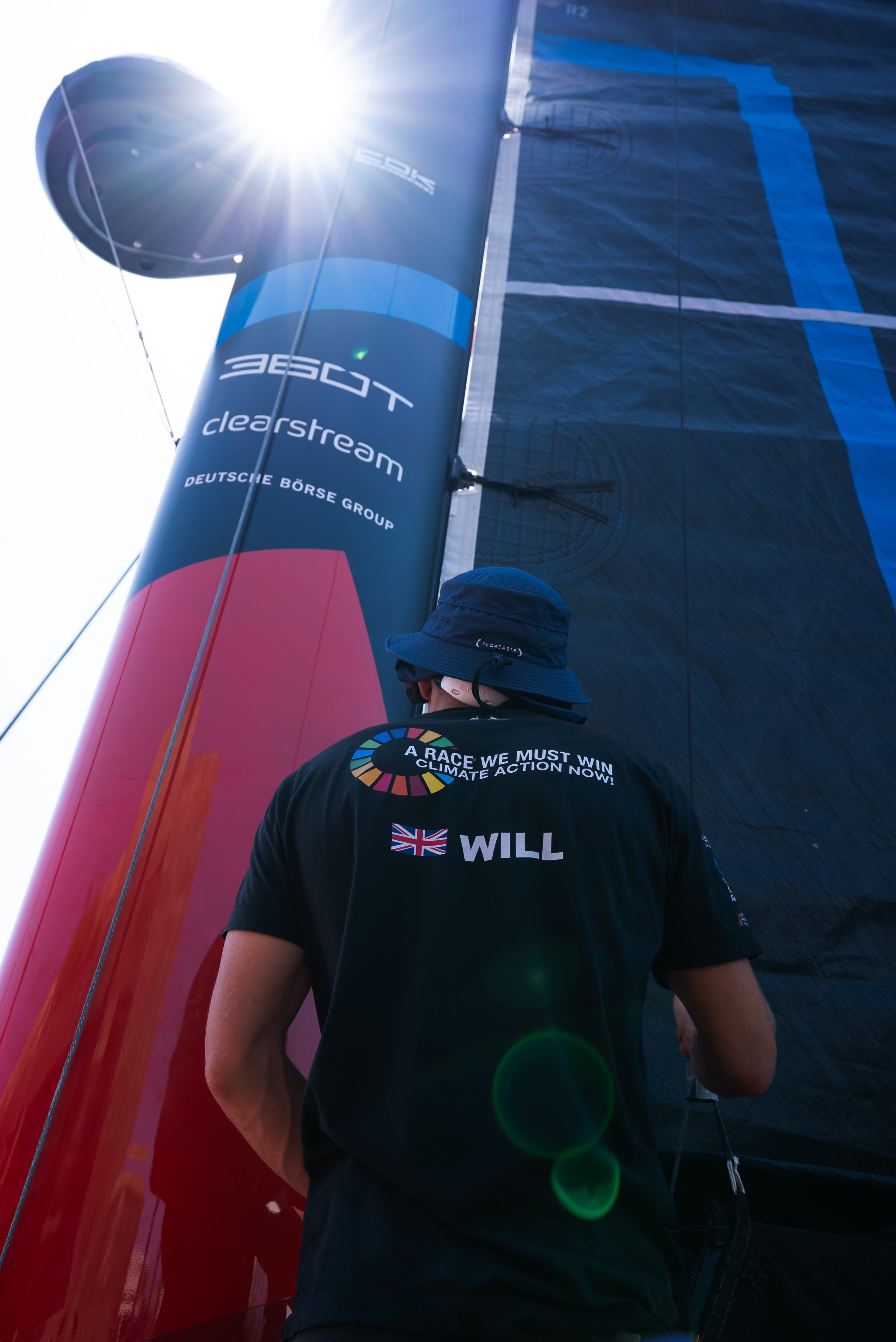 Co-skipper Will Harris standing next to the 27 m mast of Malizia 4