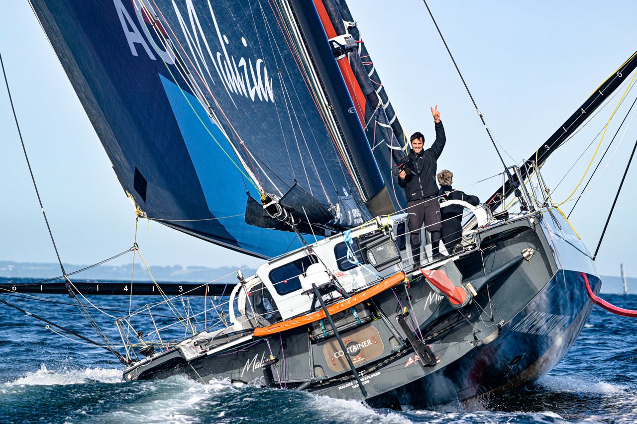 Onboard reporter Antoine Auriol waving at the Team Malizia chase boat upon arriving in Aarhus