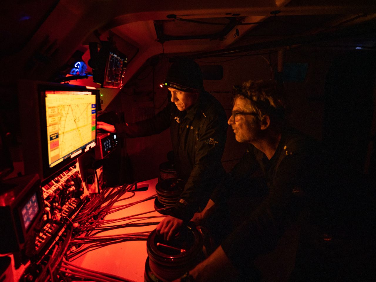 Will Harris and Yann Eliès at night in the cockpit of Malizia - Seaexplorer, trying to figure out the best strategy to close the gap to the competitors in front.