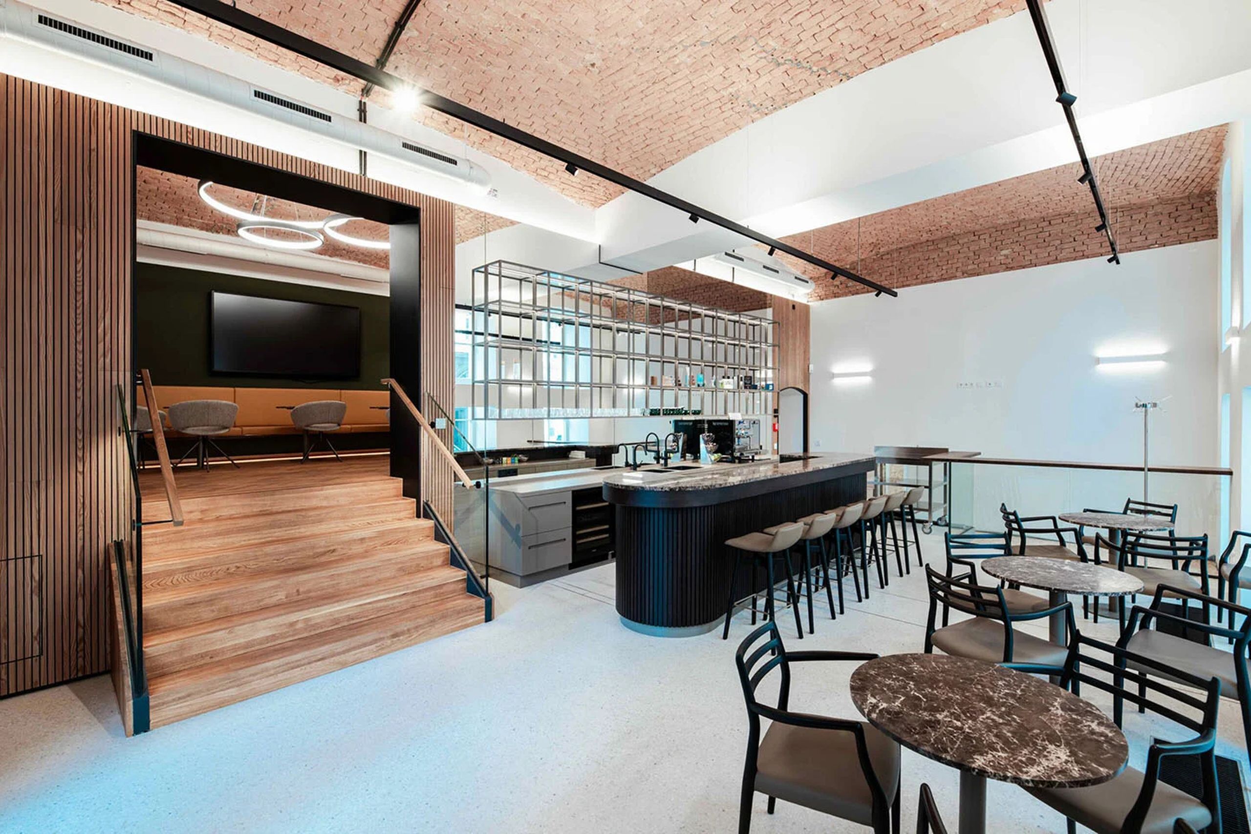Modern gestalteter Café- und Aufenthaltsbereich in der neugestalteten Bankzentrale mit Bar, Sitzgelegenheiten und offenem Raumkonzept.