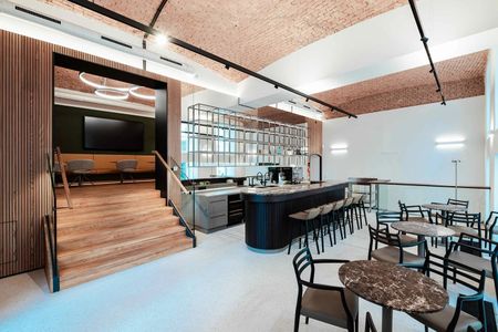 Modern gestalteter Café- und Aufenthaltsbereich in der neugestalteten Bankzentrale mit Bar, Sitzgelegenheiten und offenem Raumkonzept.
