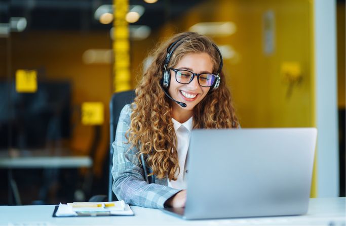 Frau am Laptop mit Headset
