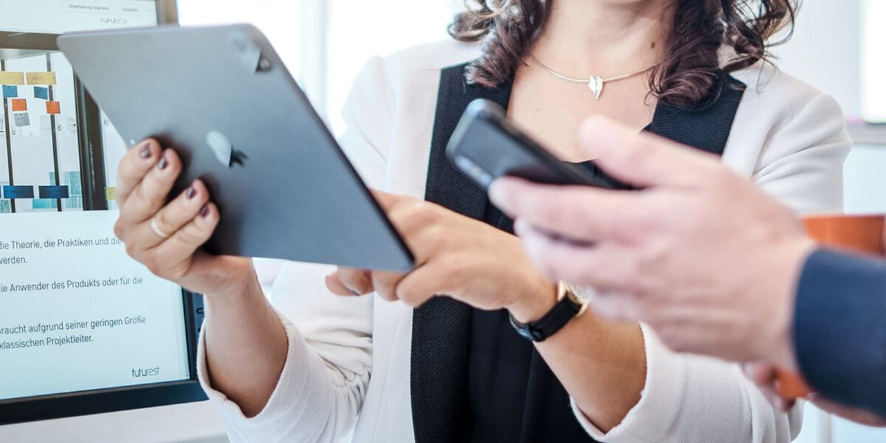 Ihr Presse-Kontakt zu uns: Hände zeigen auf Tablet und Smartphone.