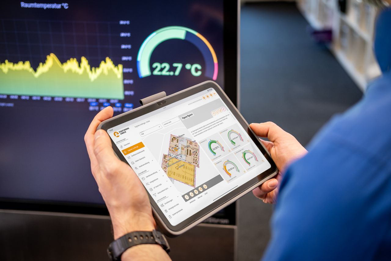 Person hält Tablet mit geöffneter Raumluftüberwachung