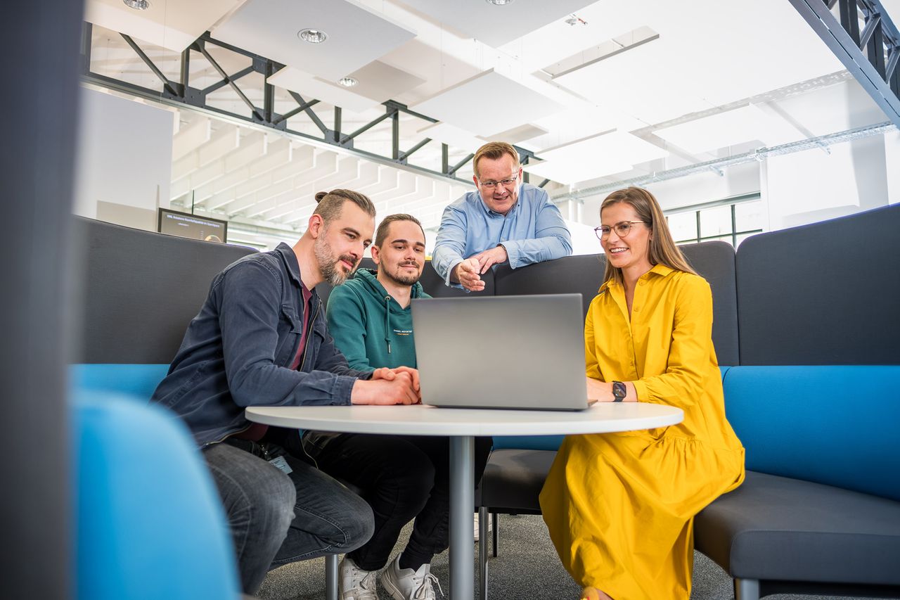 Personen besprechen was am Laptop