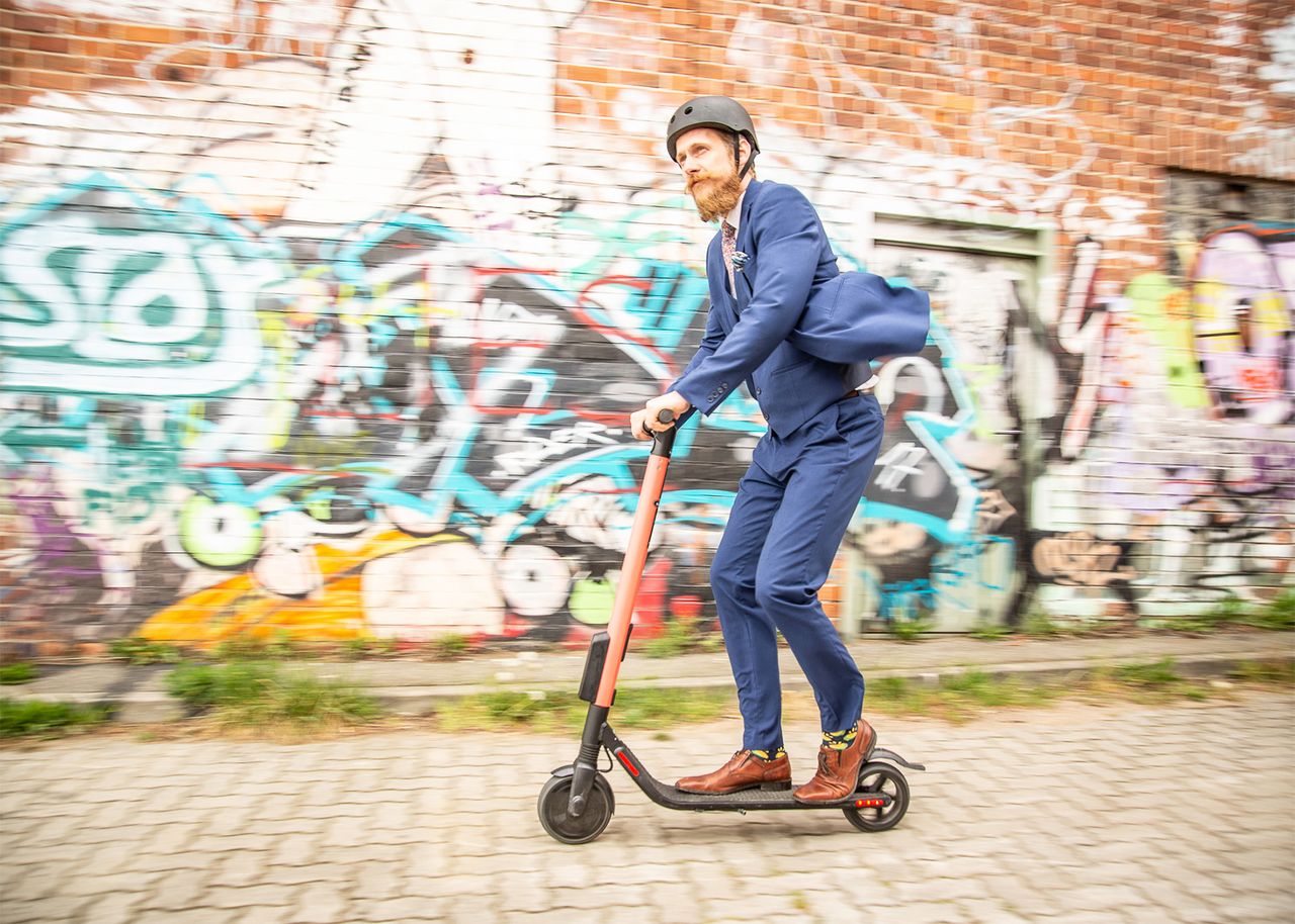 Mann fährt auf E-Tretroller durch Lübeck