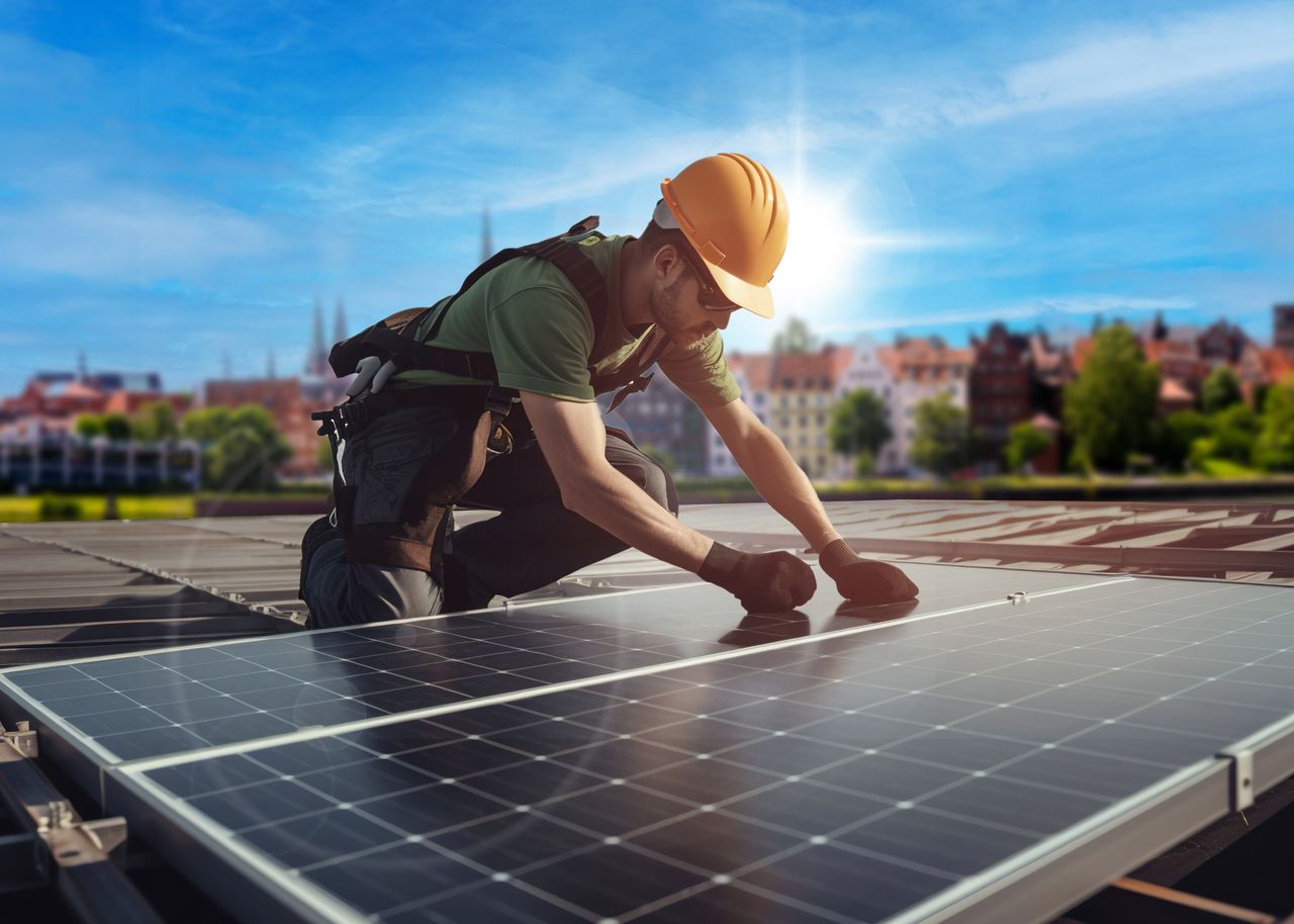 Handwerker installiert PV-Panele auf dem Dach