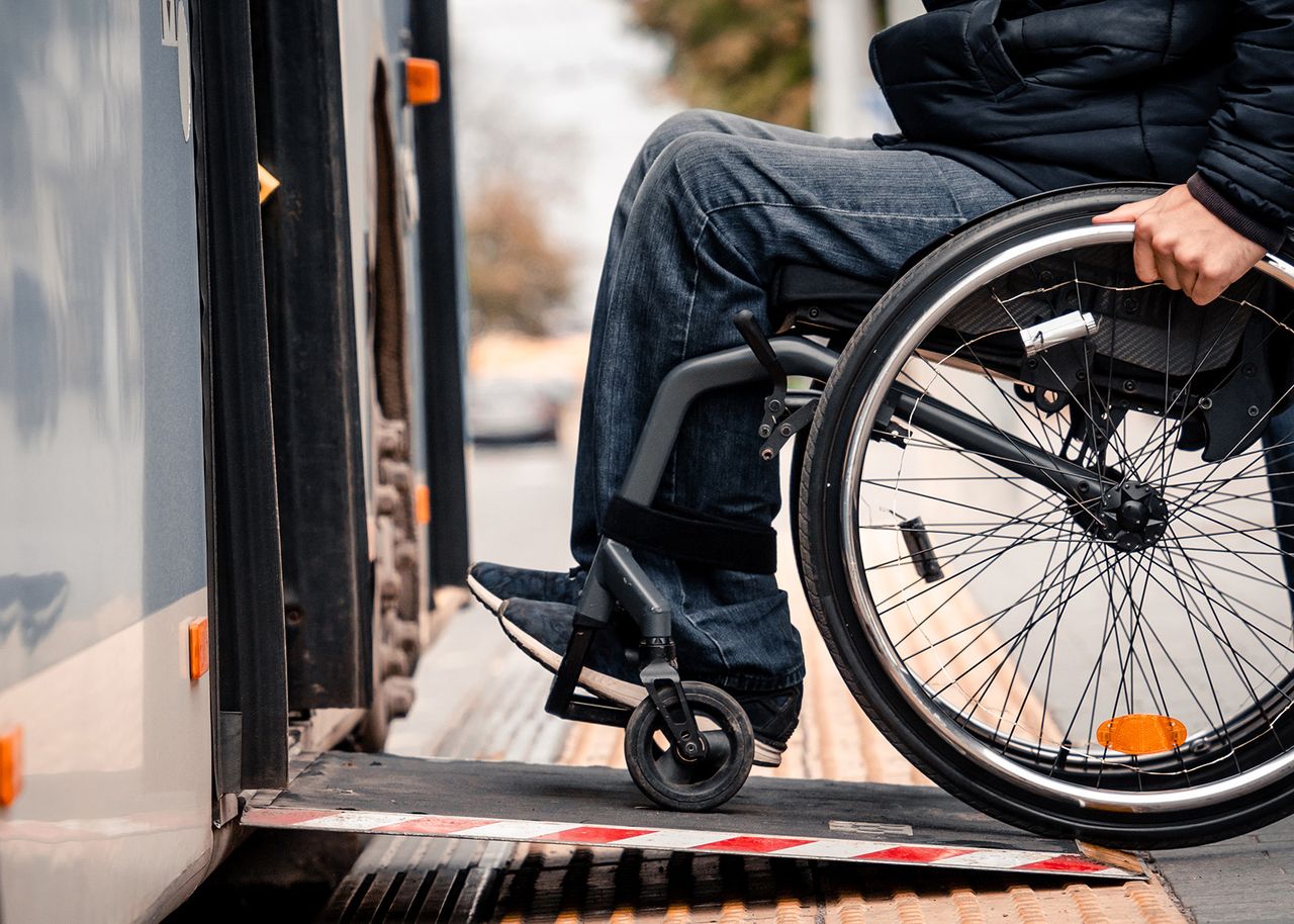Mobilitätseingeschränkte Person im Rollstuhl beim Einstieg in einen Linienbus