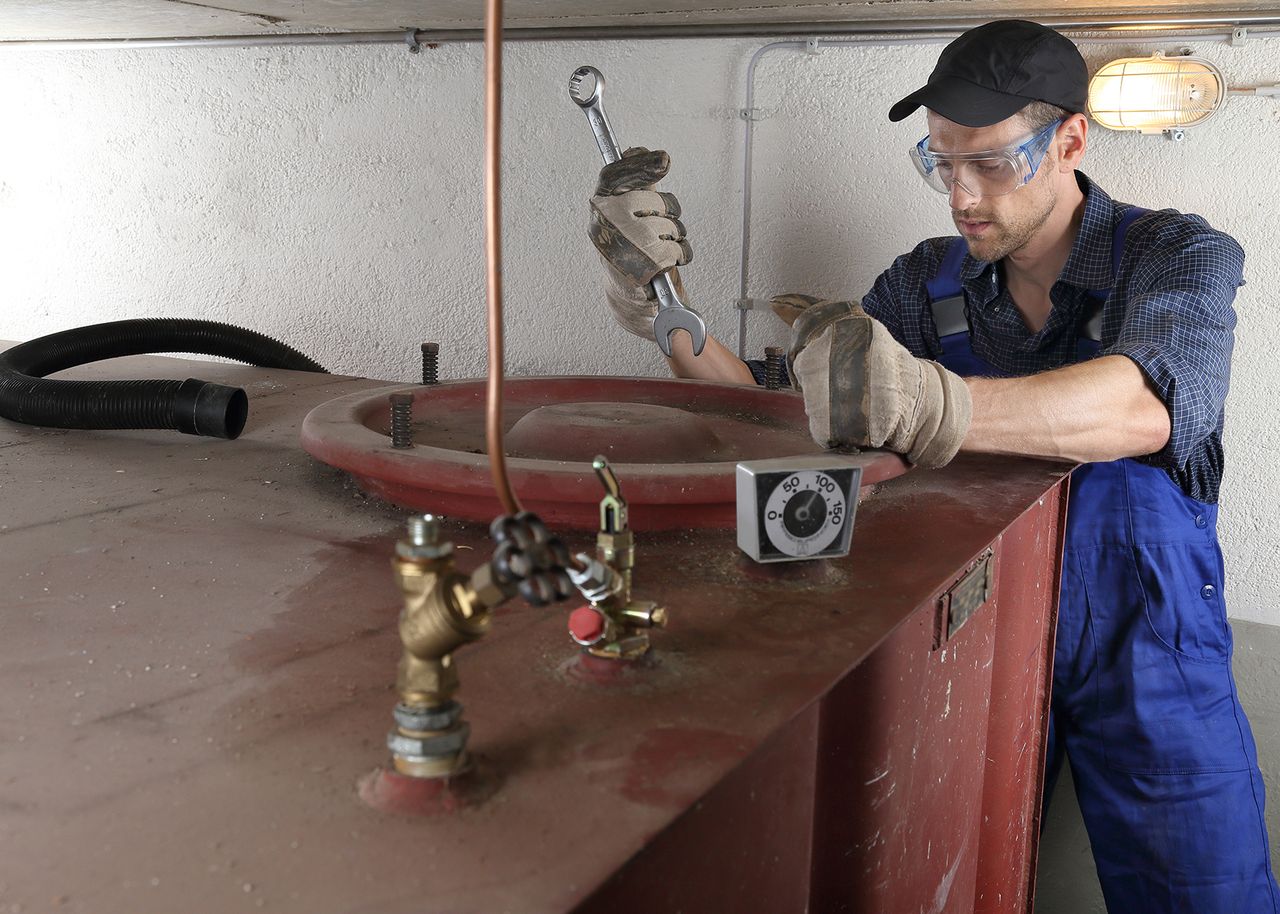 Handwerker baut Öltank aus