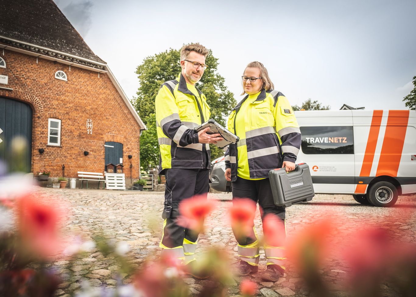 Zwei Mitarbeiter der TraveNetz schauen auf ein IPad