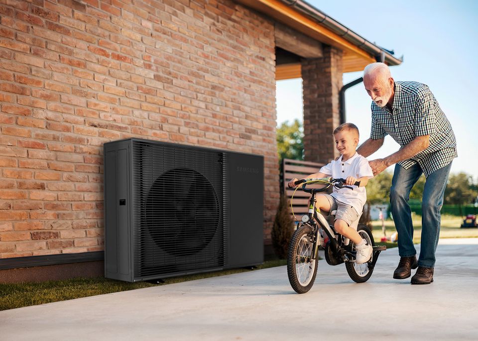 Großvater und Enkel vor Wärmepumpe
