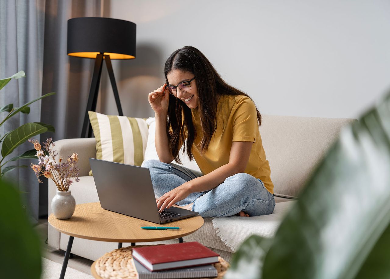 Frau sitzt vor Laptop auf dem Sofa