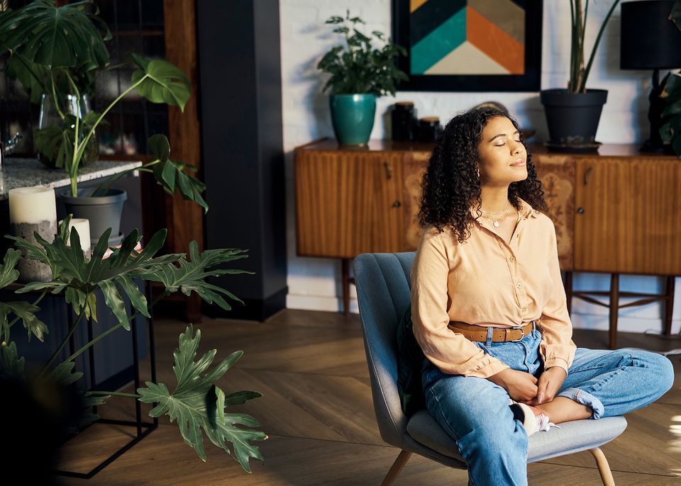 Frau sitzt auf Stuhl und entspannt sich.