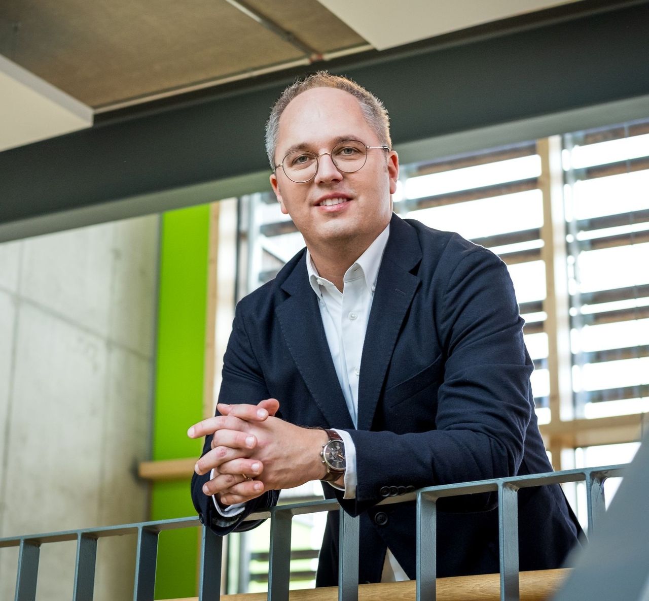 CEO Jens Meier lehnt an Geländer und lächelt in die Kamera