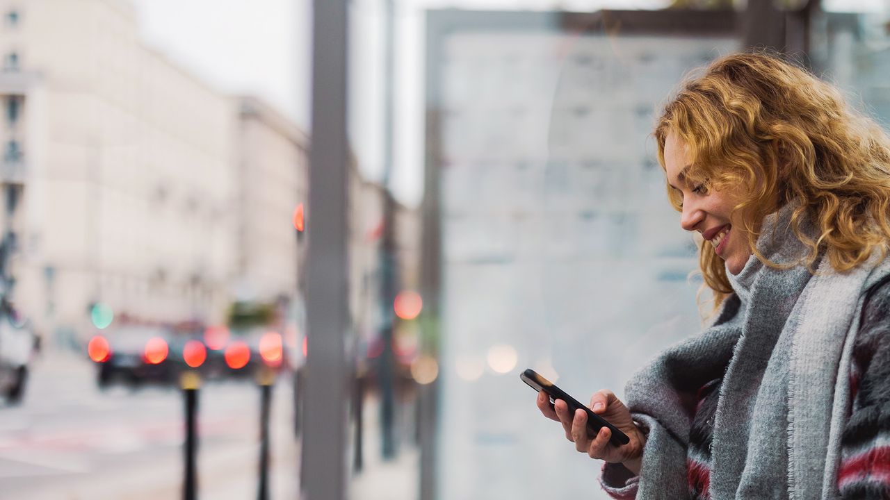 Frau lächelt auf ihr Handy