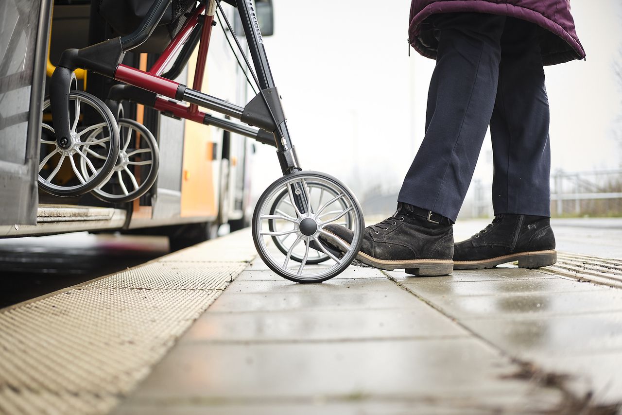 Mensch mit Rollator steigt in einen Bus
