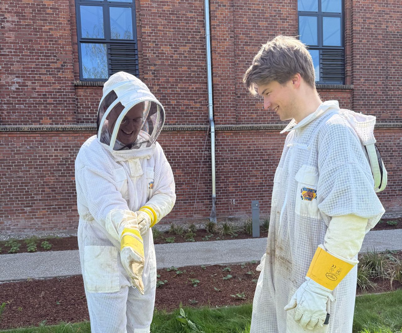 Zwei Personen im Imker Anzug, die lachen