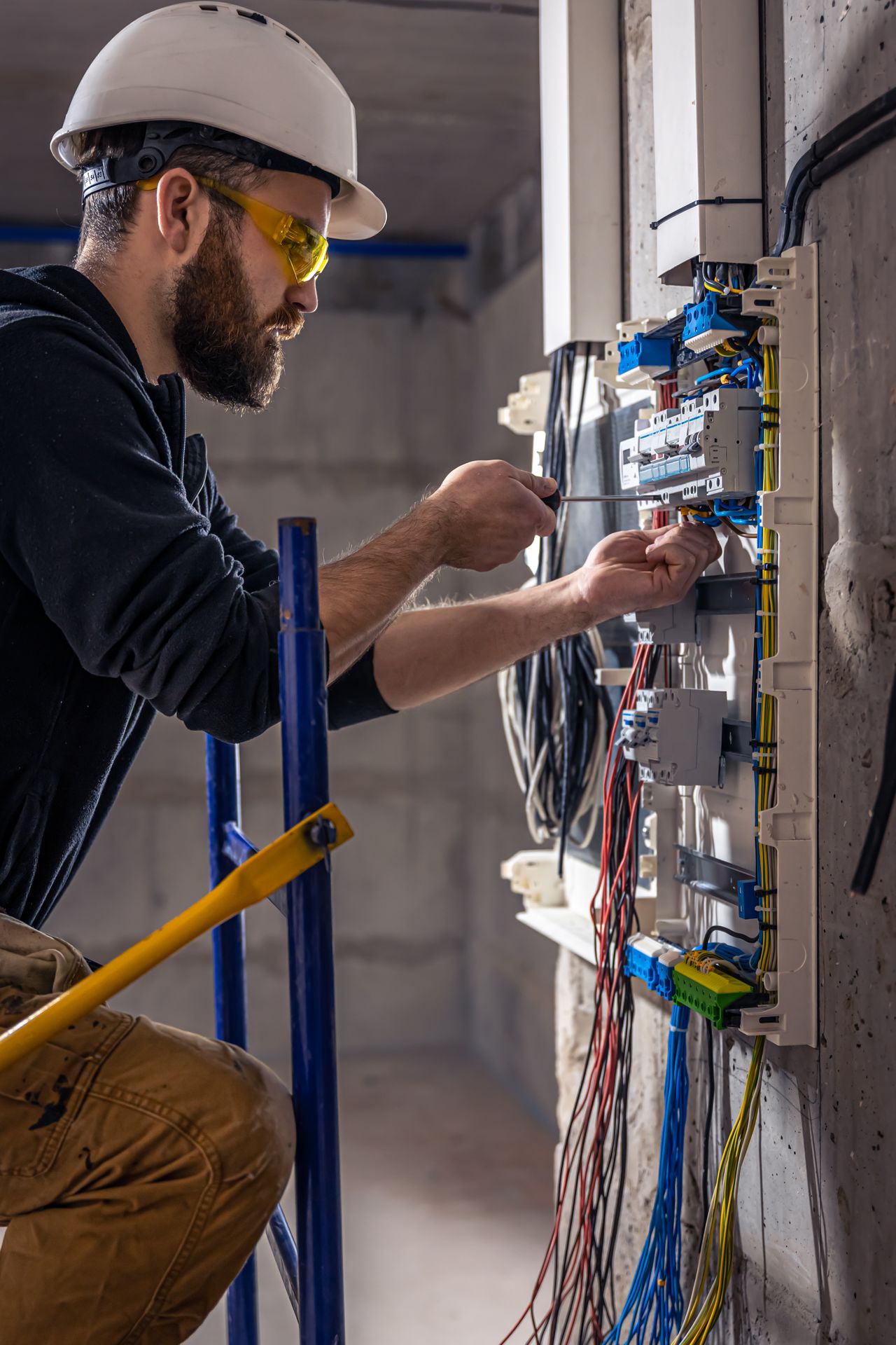 male-electrician-works-switchboard-with-electrical-connecting-cable