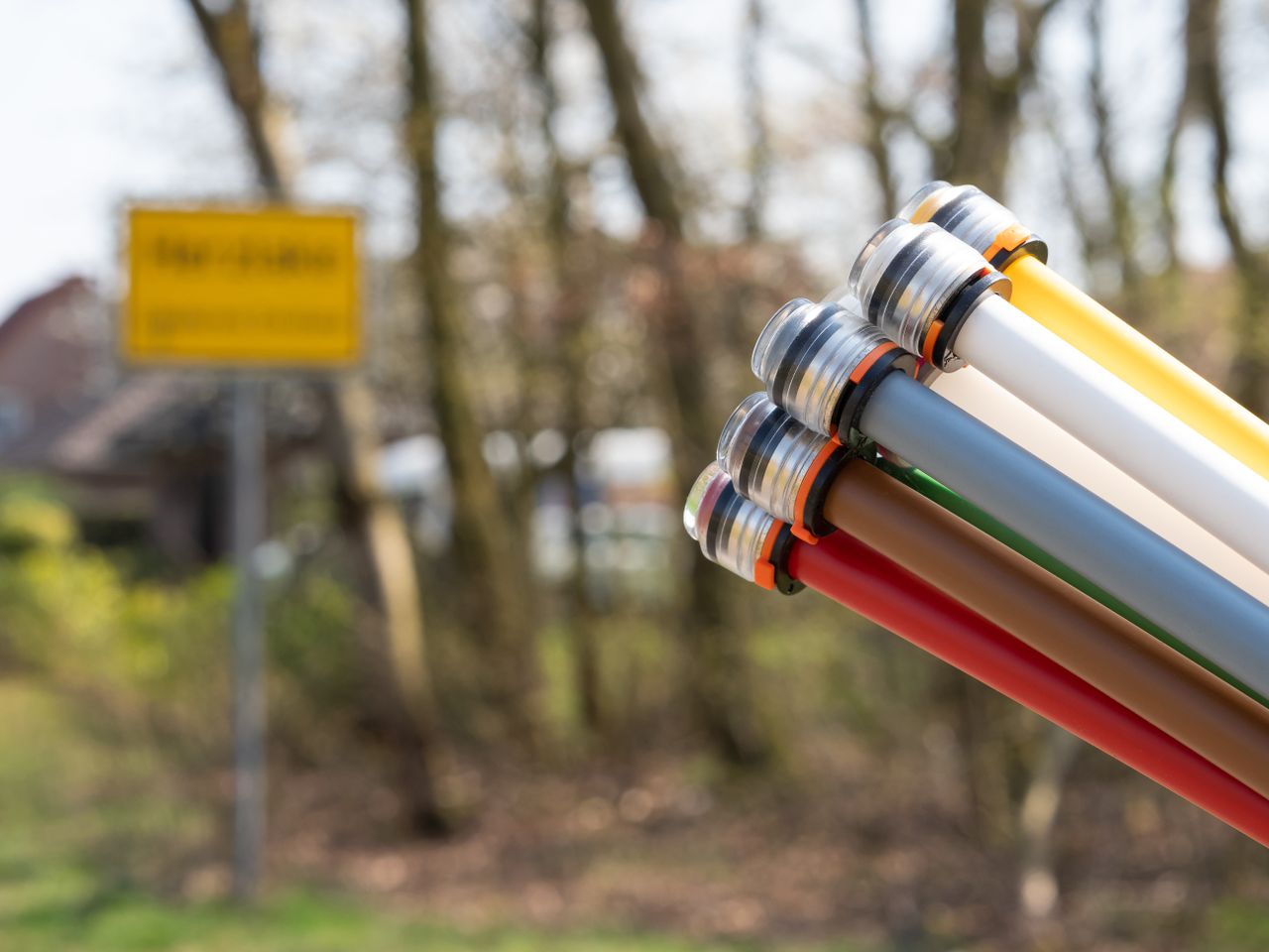 A bunch of cables in the foreground and a village sign in the background