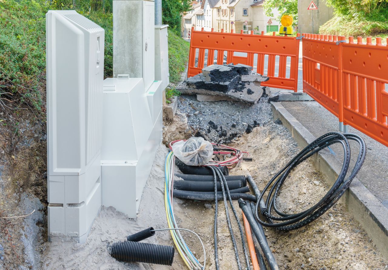 A streets sidewalk opened up for fiber construction