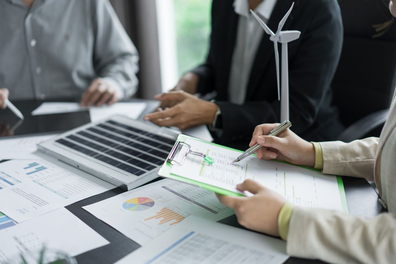 Alternative energy environment business team discuss about solar cell panel and renewable energy