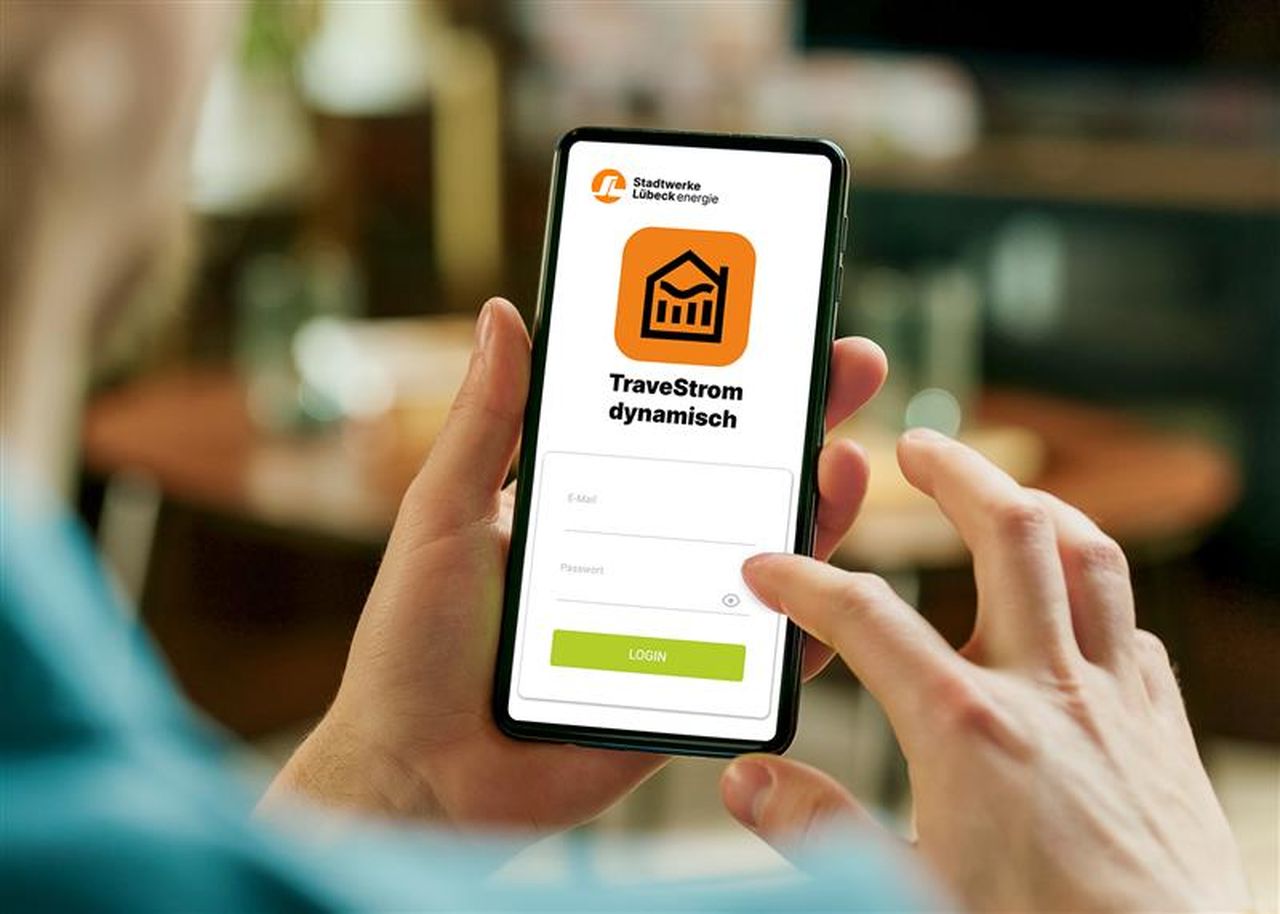 Zwei Hände halten Handy mit geöffneter TraveStrom dynamisch-App