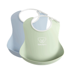 Two BabyBjörn bibs in pastel green and blue with a pocket design, featuring a bear logo on the front.