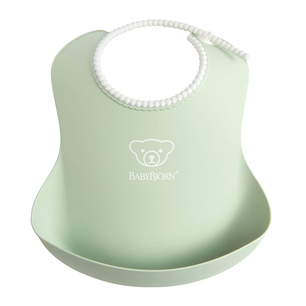 Light green BabyBjörn bib with a white beaded neck strap and a deep spill pocket, featuring a bear logo on the front.