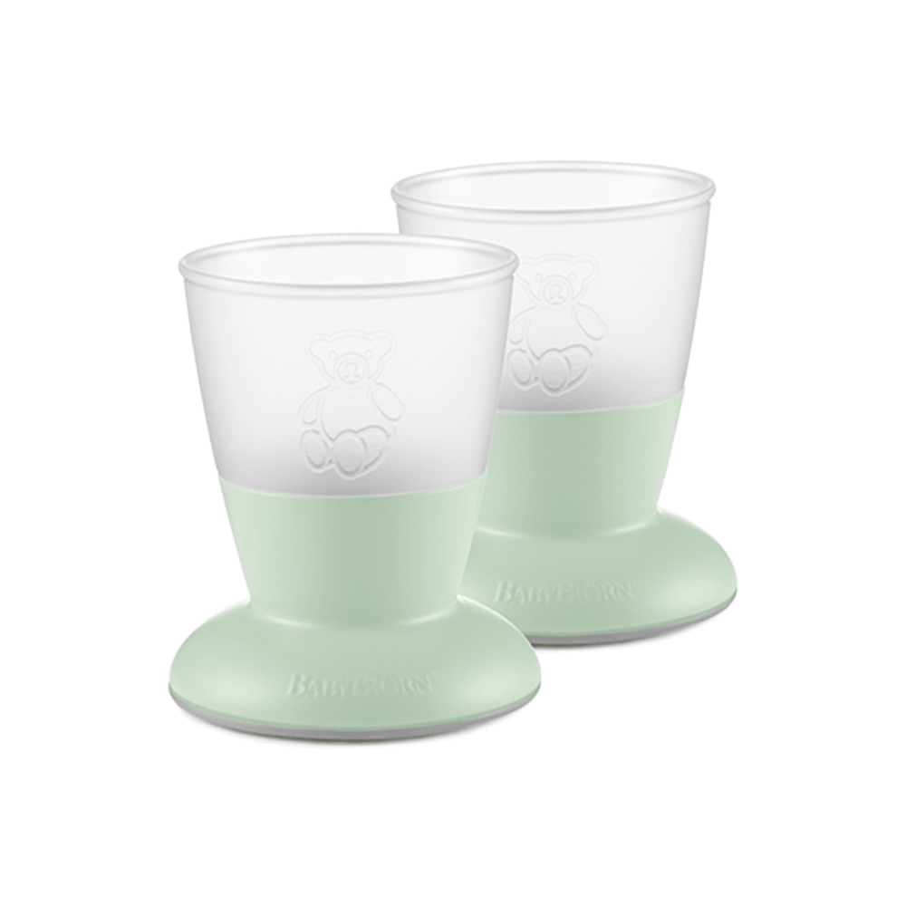 Two transparent baby drinking cups with wide bases and teddy bear designs, placed side by side.