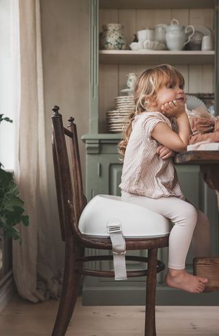 Girl in BabyBjörn Booster Seat