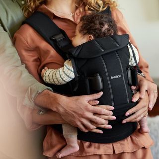 father mother and baby in baby carrier one