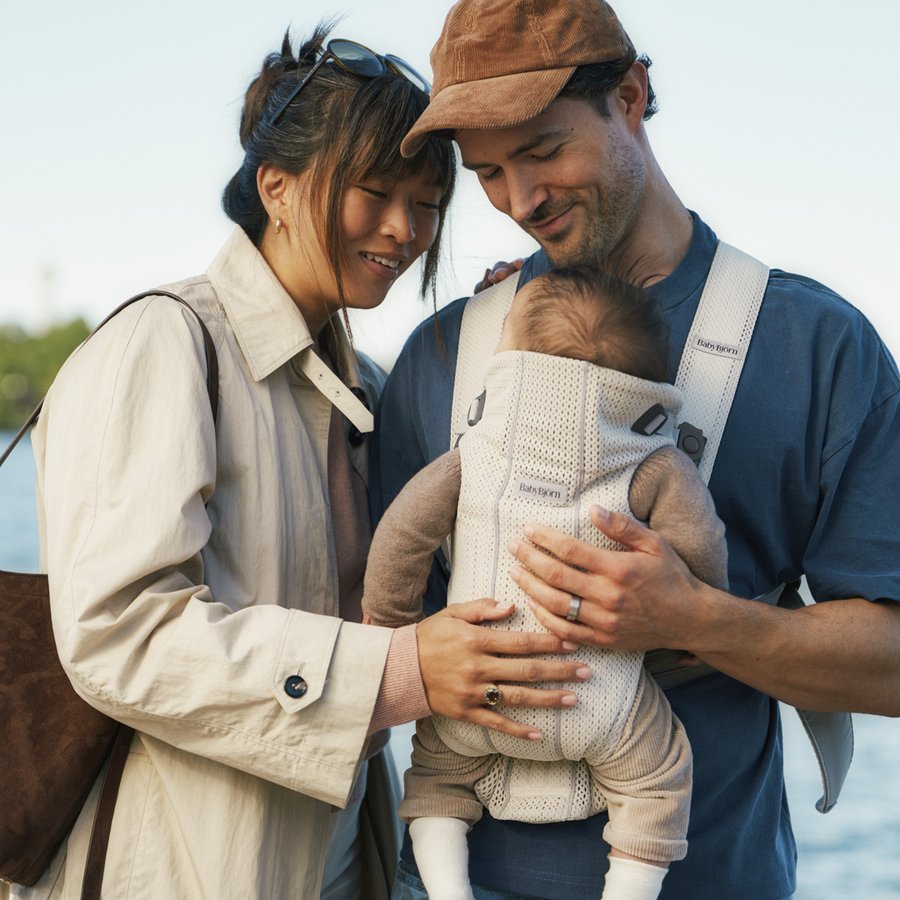 Cuplu fericit cu bebelus in marsupiu BabyBjorn afara