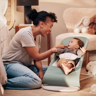 mother with baby in a baby bouncer balance soft