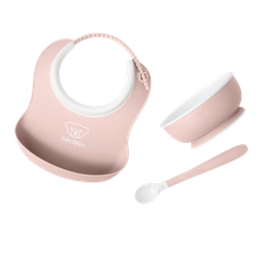 Pink BabyBjörn baby bib with food-catching pocket, plus matching pink bowl and spoon.