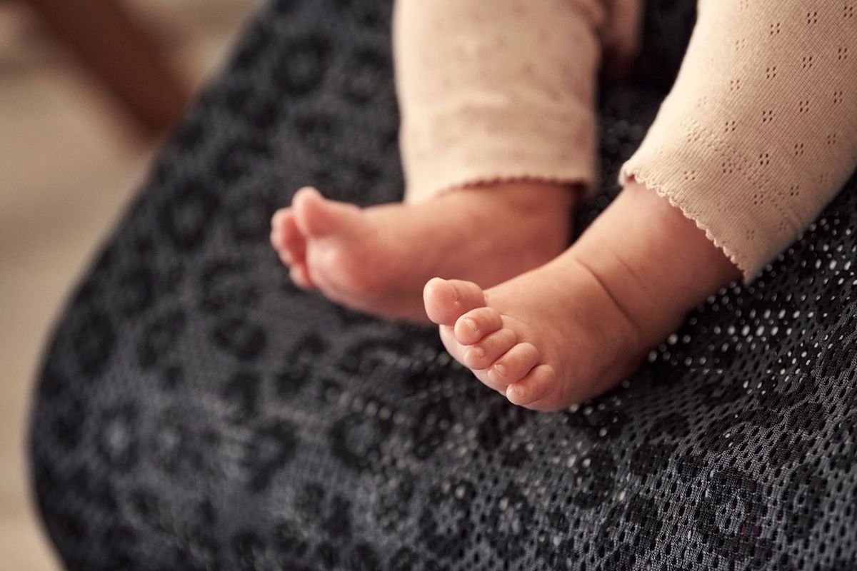 Baby feet - kid sitting in a leopard mesh bouncer - BabyBjörn