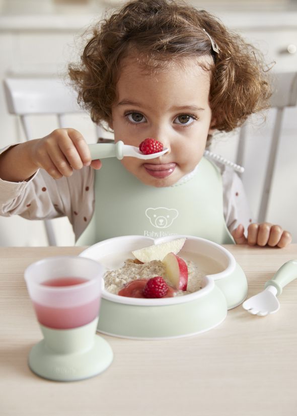 Baby Bib in powder green with a big spill pocket - BabyBjörn