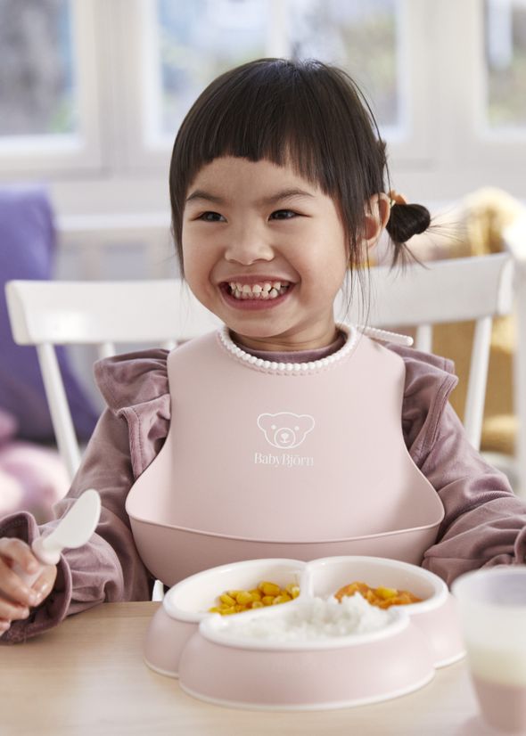 Dinnerware set in powder pink with baby plates, cup and cutlery and a bib with spill pocket - BabyBjörn
