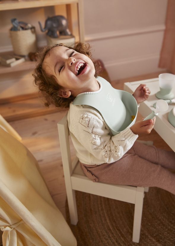 Baby Bib in powder green with a big spill pocket - BabyBjörn