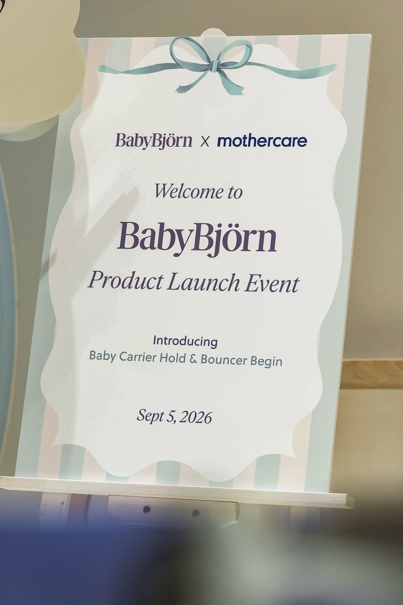 Sign for BabyBjörn x Mothercare product launch event, featuring Baby Carrier Hold & Bouncer Begin, dated Sept 5, 2026.
