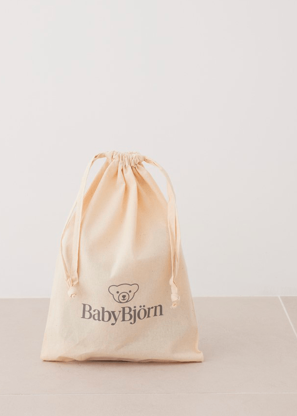 Drawstring bag with "BabyBjörn" logo and bear image, placed on a neutral-colored surface against a light background.