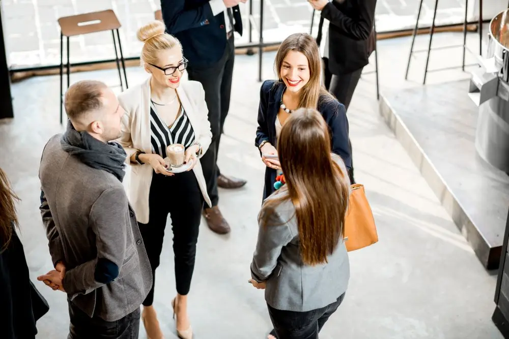 Personen in Business Kleidung unterhalten sich auf einer Veranstaltung.