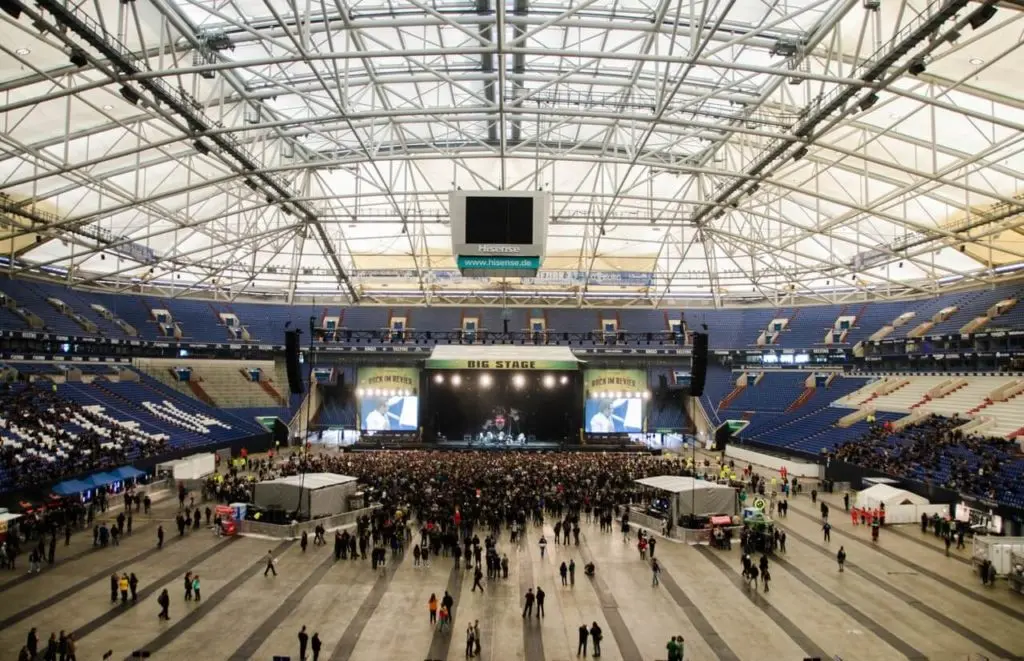 large stage in a stadium, a crowd of people in front of it