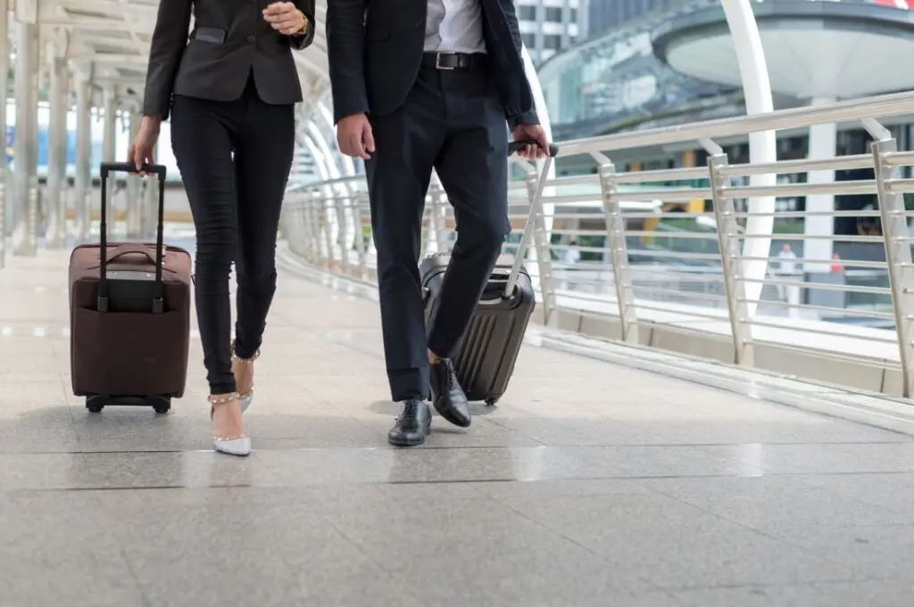 Koffer Fur Flugreise Zwei Menschen Ziehen Trolleys Am Flughafen 1024x681
