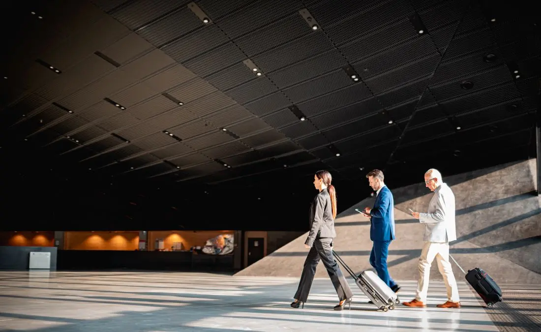 Business Travelers On The Go With Suitcases