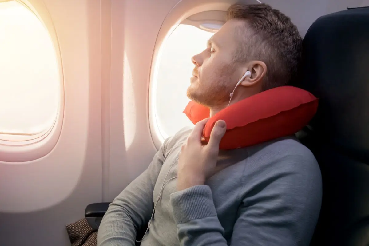 Man On Airplane Relaxing With Neck Pillow