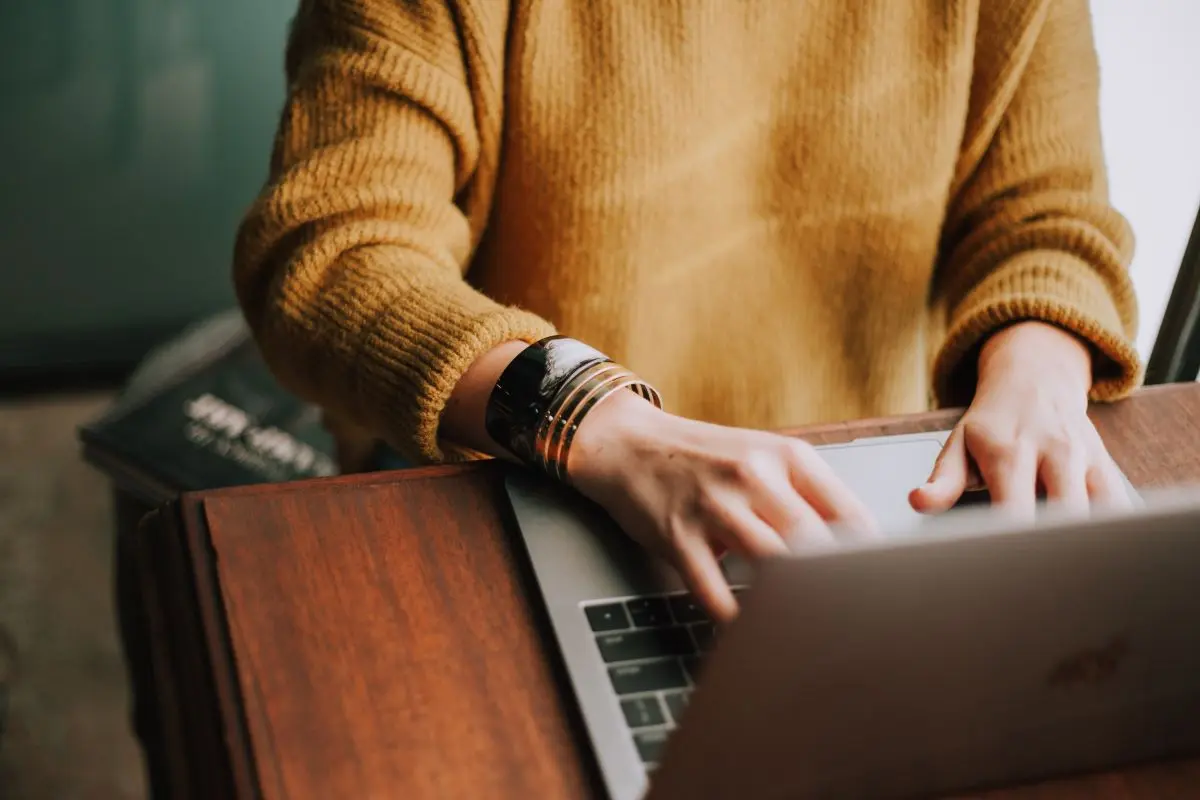 Frau In Gelbem Pullover Tippt Auf Laptop