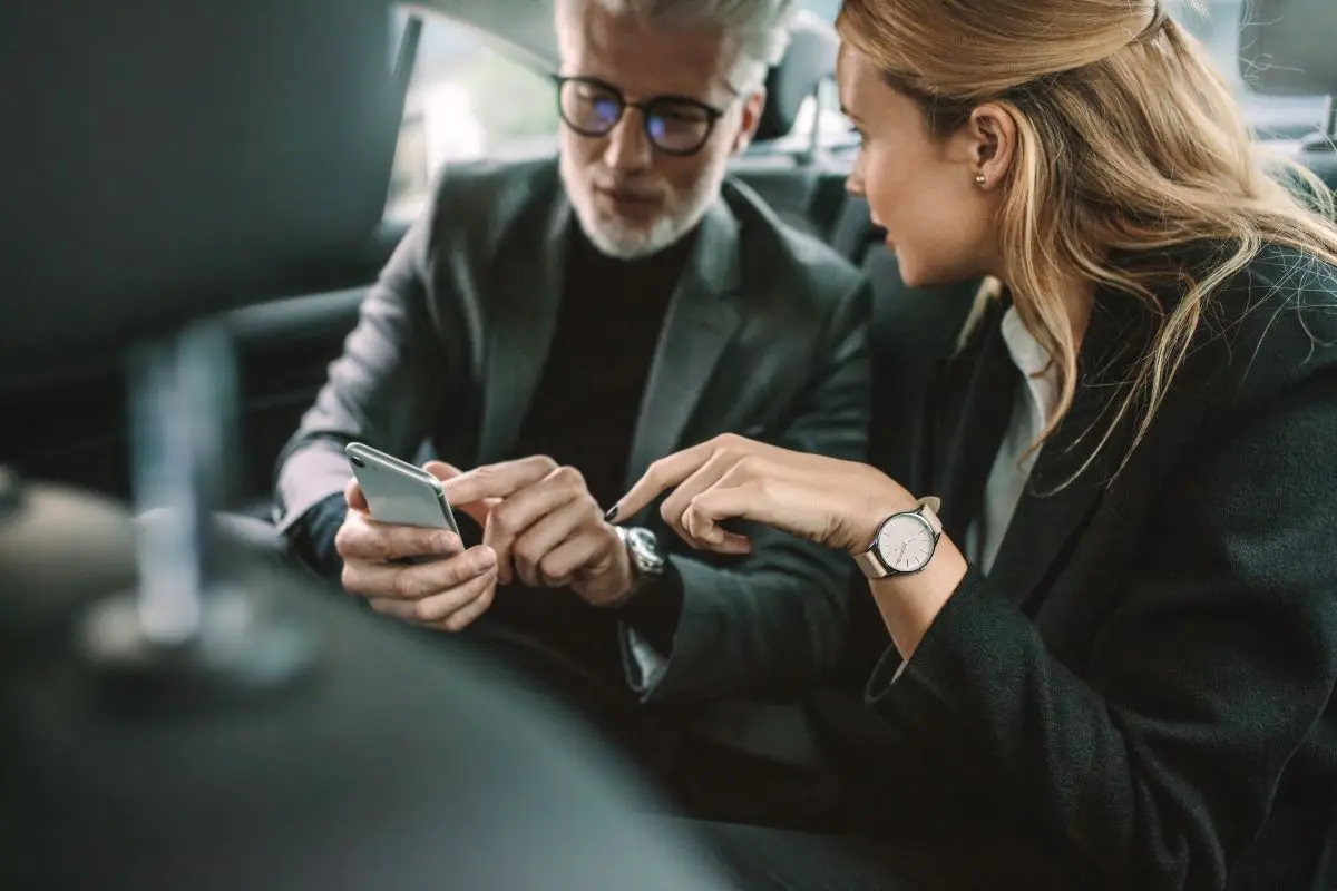 Two People Sitting In A Car And Talking