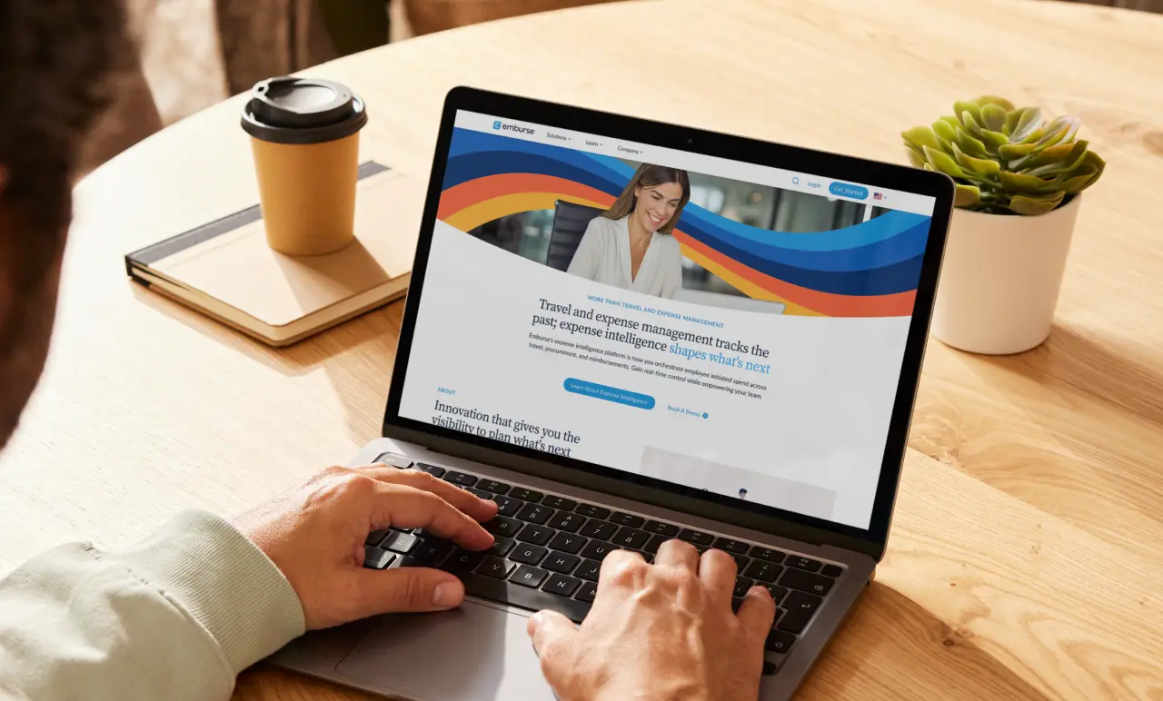 hands typing at a laptop which has the Emburse homepage on its screen