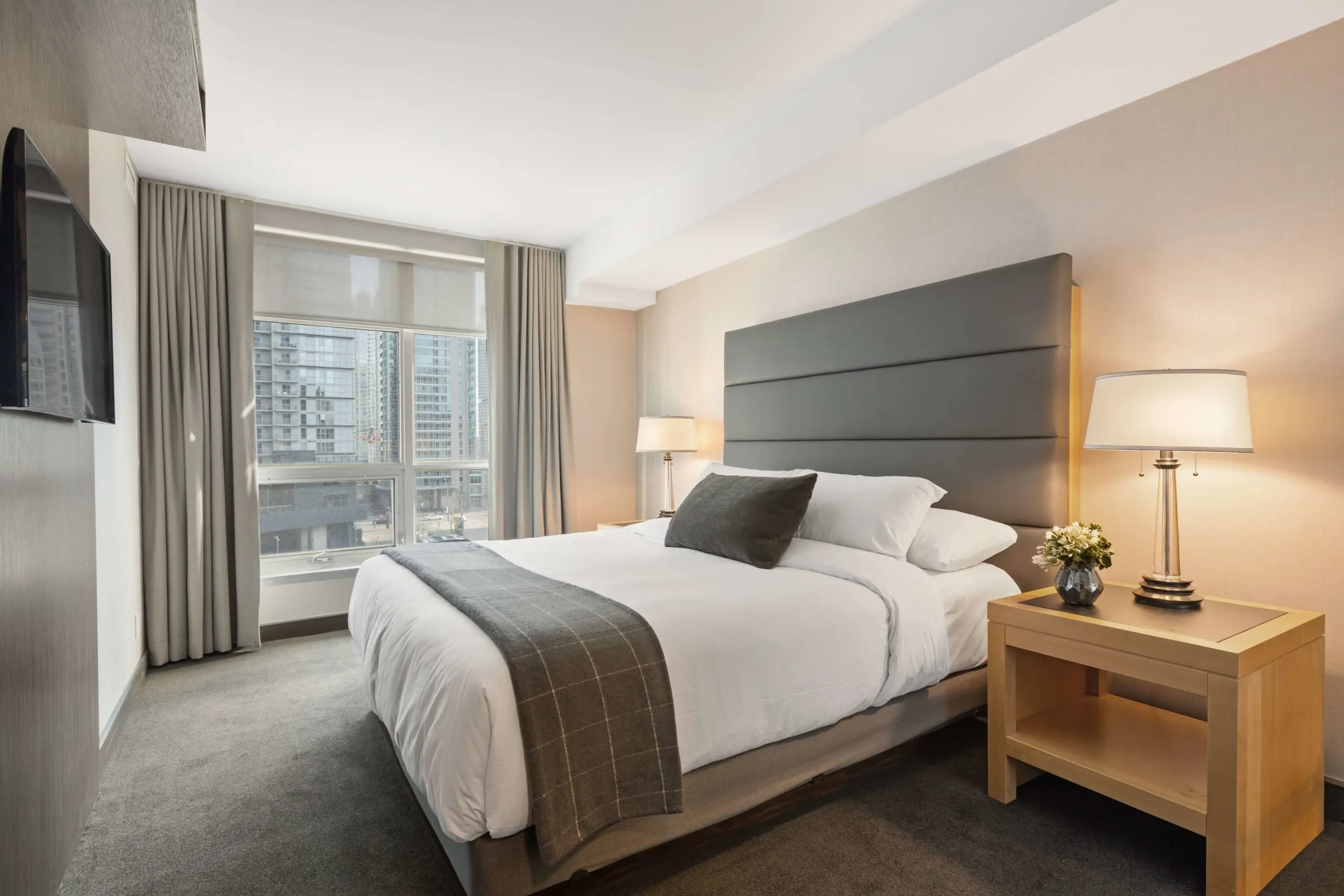 Modernes Hotelzimmer mit breitem Bett, Nachttisch und Lampen